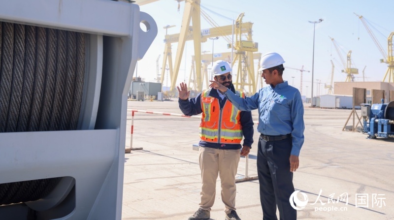 沙特阿美国王港项目经理马尔万·纳赛尔(右)在项目现场与同事交流。人民网记者任皓宇摄