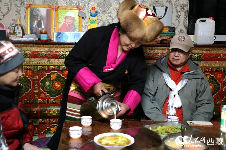 扎西曲登社区的居民在家中热情招待远道而来的游客。居民身着盛装,为游客倒上热腾腾的酥油茶,桌上摆放着切玛与特色美食,宾主共话民族团结情谊。人民网记者 吴雨仁摄